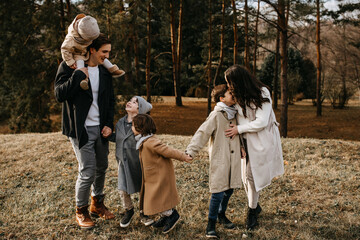 Big family walking outdoors in a park. Family spending fun time together on an autumn day.