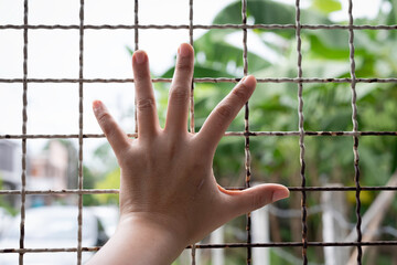 Human hand touch on wire mesh