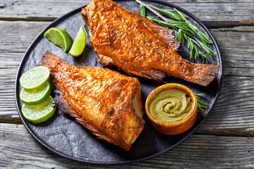 two fried ocean perch with rosemary and lime