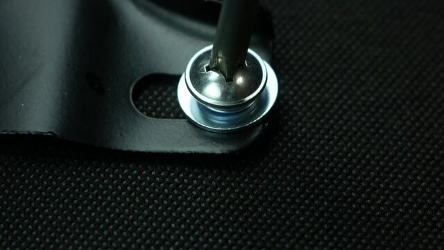 Close-up of the assembly of cabinet upholstered furniture. The furniture assembler fixes the elements of the structure with a screw. Use a screwdriver to tighten the screw. Selective focus,