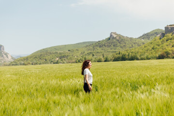 woman tourist walking through a field of wheat on a journey