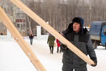 Worker assembling the frame of a wooden slide