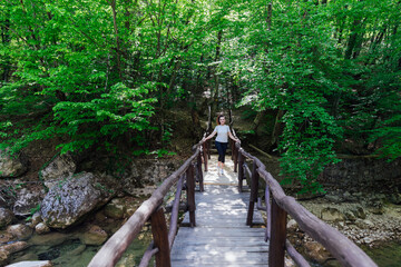 Obraz premium beautiful tourist woman walking through the green forest on a journey