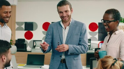 A large group of co-workers and managers are having a friendly meeting in a large modern office. 4k