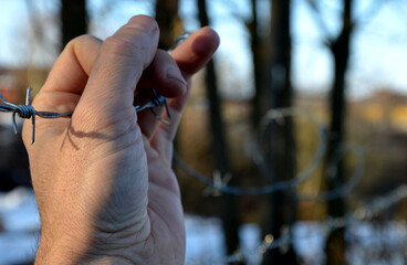 overcoming a barbed wire fence, roadblock with concrete cones against vehicles. the iron curtain...