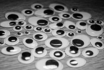 Many plastic eyes on a wooden background. Lots of eyes.