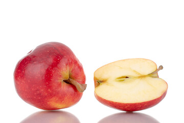 One half and one whole organic red apples, close-up, isolated on white.