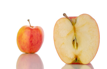 One half and one whole organic red apples, close-up, isolated on white.