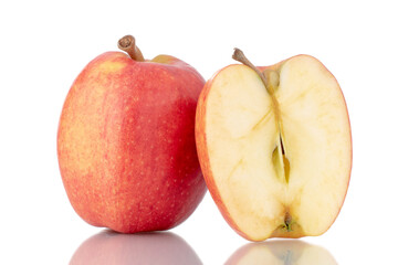 One half and one whole organic red apples, close-up, isolated on white.