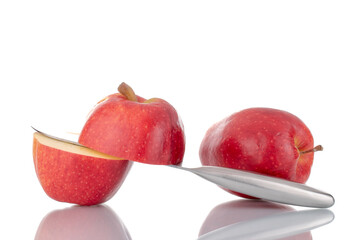 Two halves and one whole organic red apples with a knife, close-up, isolated on white.