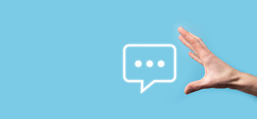 Businessman holding a message icon, bubble talk notification sign in his hands. Chat icon, sms icon, comments icon, speech bubbles