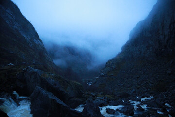 Dark and cloudy Norwegian morning. Rain in Norway. Fog in the mountains. Languid mountains. Stones. Boulder. Rock. Waterfalls in the wild mountains. Mountain river. © Hanna Ohnivenko