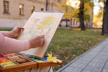 Woman drawing with soft pastels on street, closeup