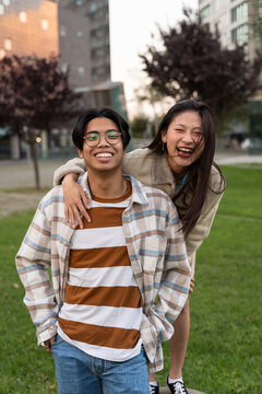 Happy Asian teenager friends embracing and having fun together, wearing trendy clothes, positive emotions