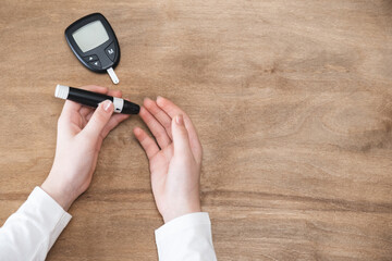 Diabetes checking blood sugar level. Child using lancelet and glucometer