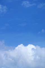 Fototapeta premium White cumulus clouds on bright blue sky 