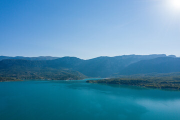 The Lac de Sainte-Croix surrounded by green mountains in Europe, France, Provence Alpes Cote dAzur, Var, in summer, on a sunny day.