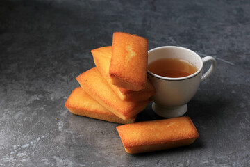 Delicious French Financiers Cake  with Fresh Butter, Served with Tea. Copy Space for Text. On Grey Cement Background