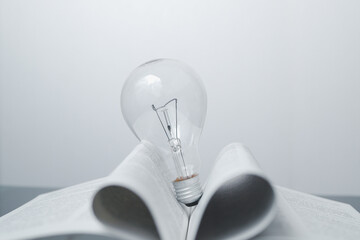 the light bulb that glows on the book Offer inspiration from reading. innovative idea or knowledge...