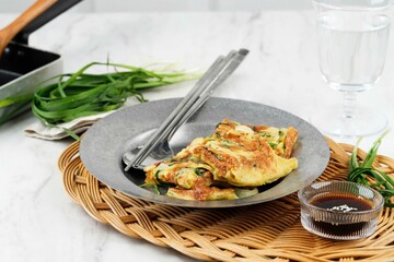 Chives Pancake, Popular as Pajeon Pancake in Korea. Made from Egg, Flour, Onion, and Chives or Green Onion (Scallion). Served with Soy Suce and Sesame Seed Sprinkle