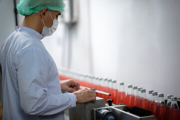 food technician control checking production line of water drink in manufacturing factory