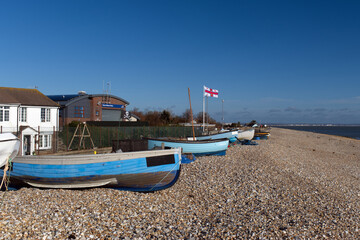 Wooden fishing boats lined up on the shingle of East Beach in Selsey, a popular seaside resort in West Sussex Southern England.