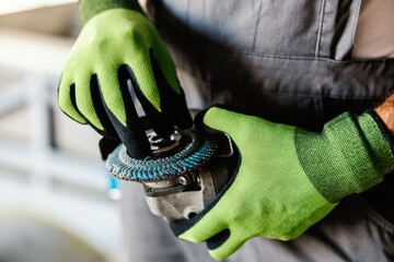 Close up of hands adjusting grinder for work. Hands and grinder. Worker in heavy industry.