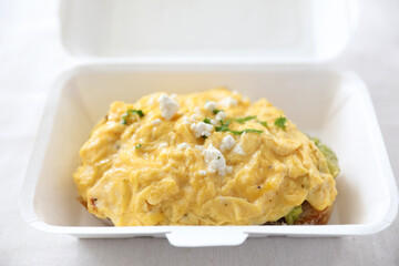 Avocado and scrambled eggs toast with delivery package in white background