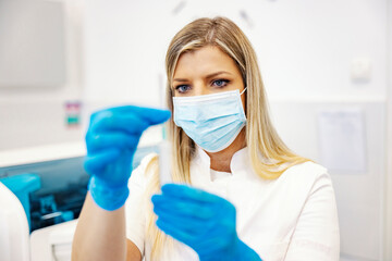 Innovation in a lab. A nurse standing in a laboratory and preparing a syringe with a vaccine for a...