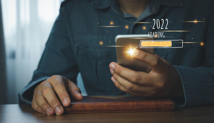 Loading new year 2022.Human using mobile phone technology. Symbol of new year countdown to 2022 celebration. business management  goal strategy and action plan. Global customer network connection.