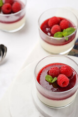 Italian dairy dessert panna cotta with raspberry jam and fresh raspberries on marble board