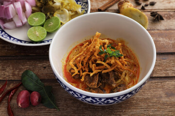 Local northern Thai food Egg noodle curry with beef on wood background