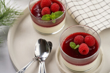 Italian dairy dessert panna cotta with raspberry jam and fresh raspberries on concrete tray