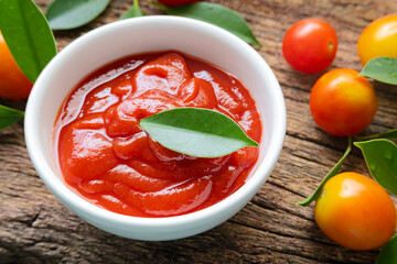 Close up fresh homemade tomato sauce in white bowl placed on a wooden background