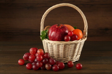 Fresh ripe fruits and wicker basket on wooden table