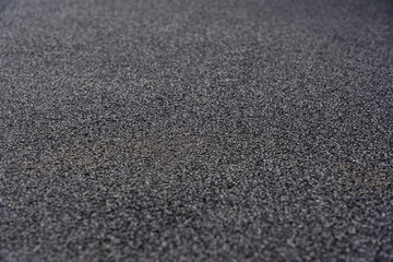 Rubber floor black texture background. Black rubber crumb coating on the sports field. selective focus