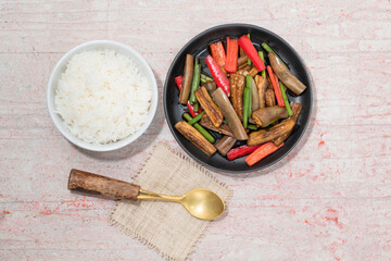 Bowl rice and fried eggplant in plate on red background.