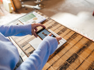Anonymous jeweler taking picture of rings on table