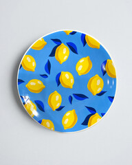 Elegant cutlery view from above on a isolated white background. Top view. Porcelain saucer with blue leaves and yellow lemons on the azure color. Trendy plate pastel shades. Flat lay view.