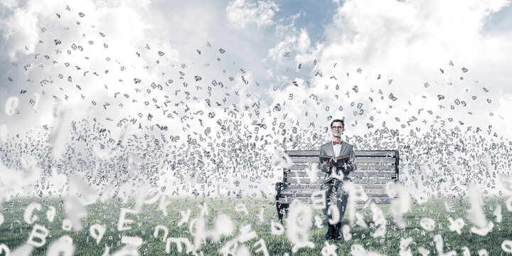 Young businessman or student studying the science and symbols fly around