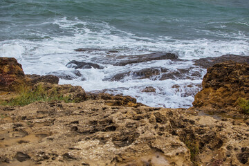 Fototapeta na wymiar Surf on a rocky seashore