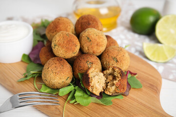 Delicious falafel balls with herbs on white table, closeup
