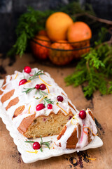 Traditional Christmas cake decorated with glaze, cranberries and rosemary