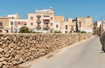 Urban street with typical mediterranean houses on the island Favignana, one of the Egadi Islands in the Mediterranean sea of Sicily, province of Trapani, Italy
