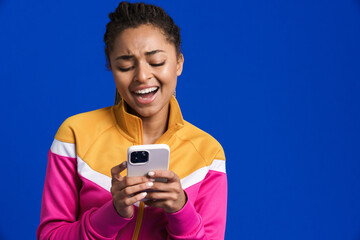 Black young woman laughing and using mobile phone