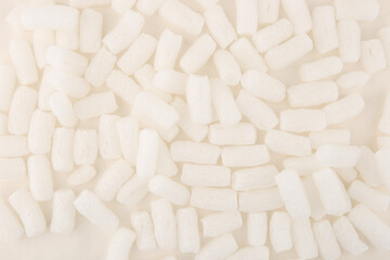 Fototapeta na wymiar Styrofoam packing peanuts background. White plastic foam pellets protective for parcel packing.