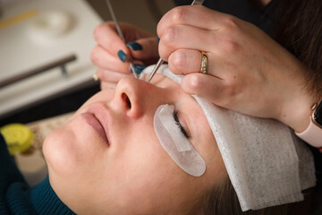 Obraz na płótnie Canvas Eyelash extensions. A girl in a cosmetology salon.