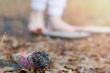 A bunch of herbs for aromatherapy and fumigation while meditating outdoors with bare feet on a sadhu board. A swirl of field grasses smokes while lying on the ground. Yoga, board with nails. Copyspace