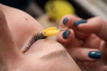 Eyelash extensions. A girl in a cosmetology salon.