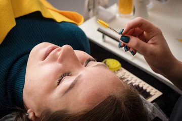 Eyelash extensions. A girl in a cosmetology salon.